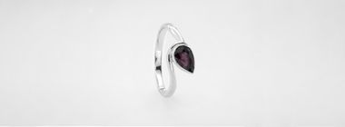 Silver ring with a purple stone on a white background